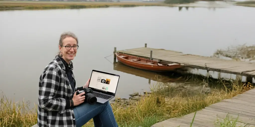 Susann Prüß mit Kamera und Laptop am Steg – Webdesign & Fotografie in Glückstadt